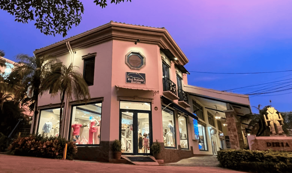 Romantic pink building housing a boutique in Tamarindo, Costa Rica, with twilight sky backdrop.