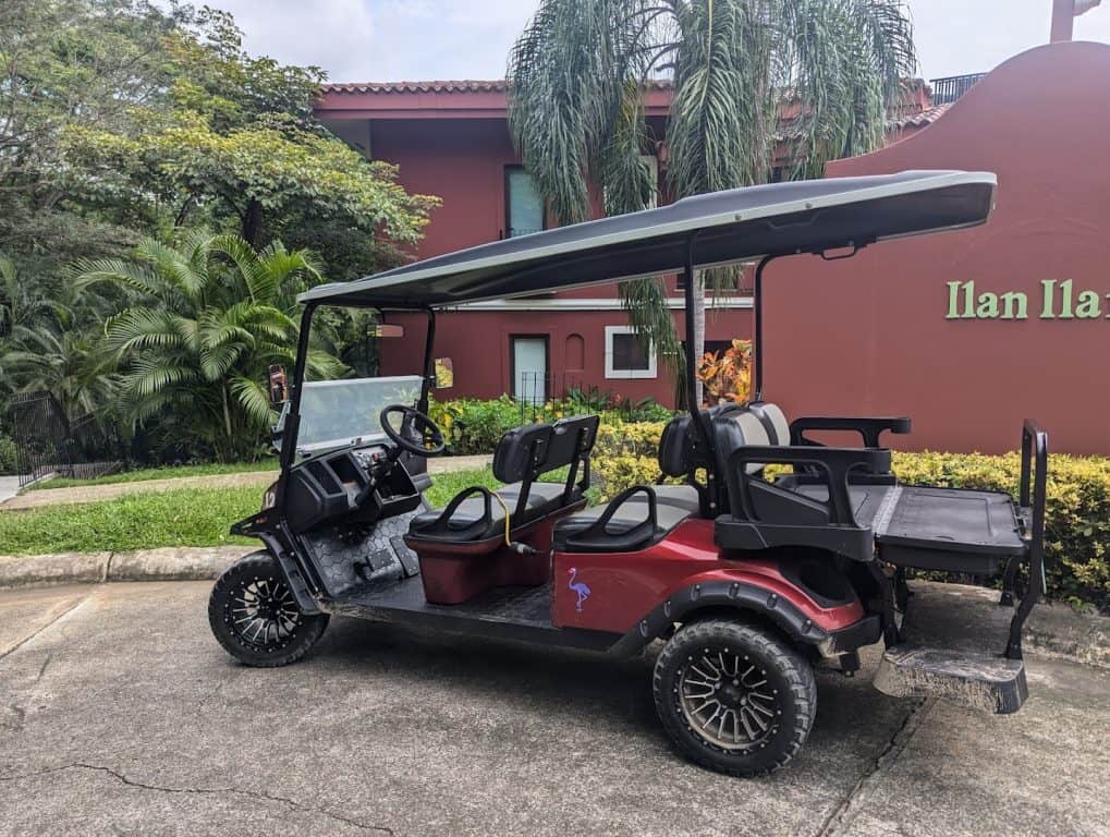 Golf cart parked outside resort, lush tropical landscaping in Tamarindo, Costa Rica.