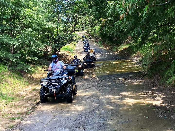 atv tour group riding jungle trail