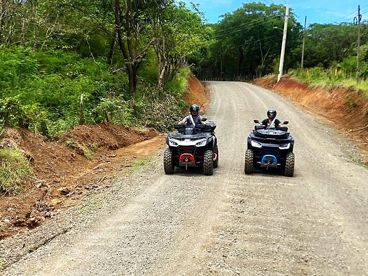 two atvs on hillside dirt road