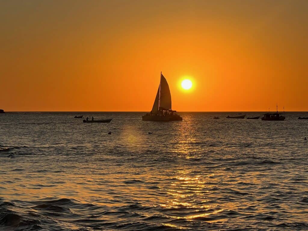 Catamaran silhouette sailing at sunset on the Pacific