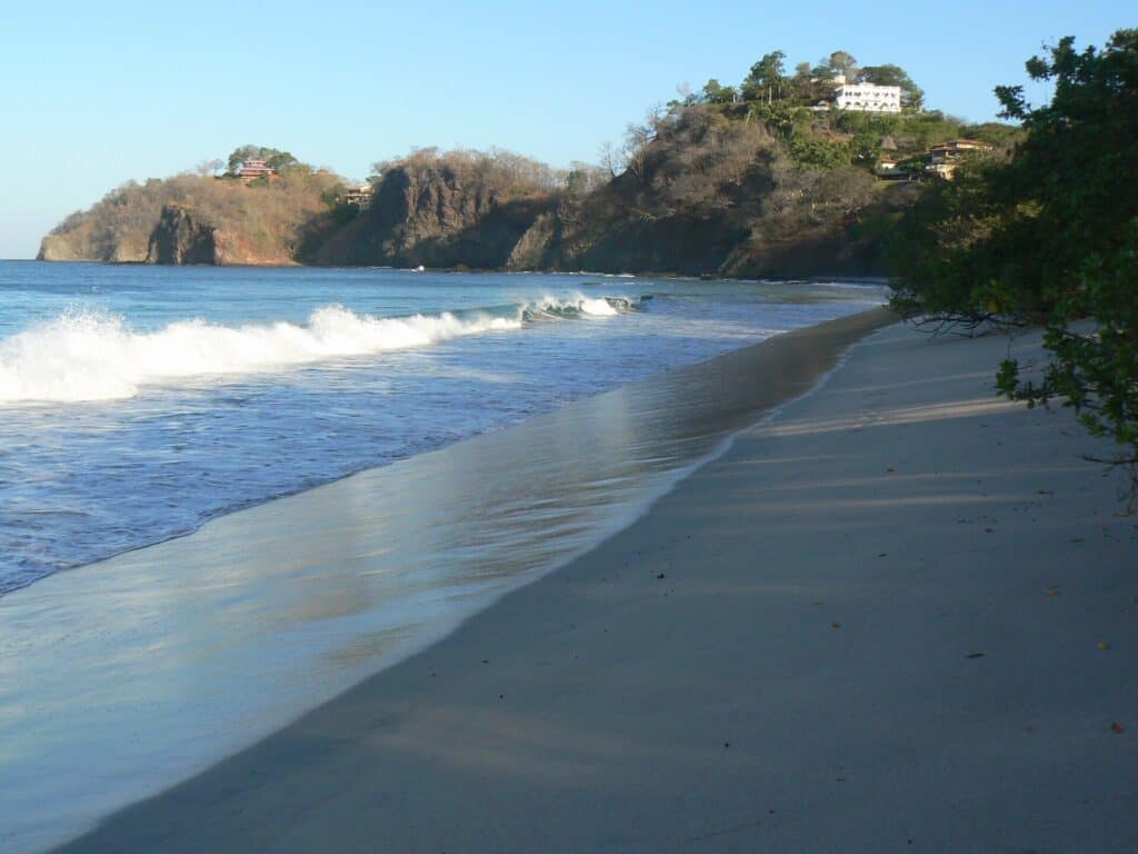 Waves along Playa Flamingo with the rocky north point behind