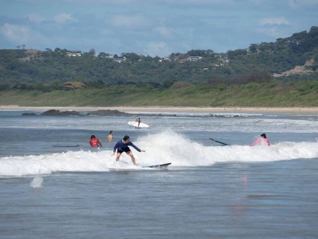Surfers riding a wave near the river mouth in Tamarindo